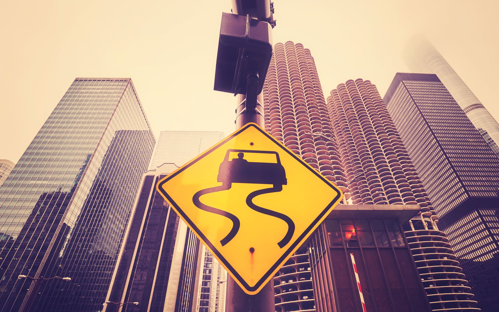 color-toned-slippery-road-sign-with-chicago-skyscr-PJWN4YQ
