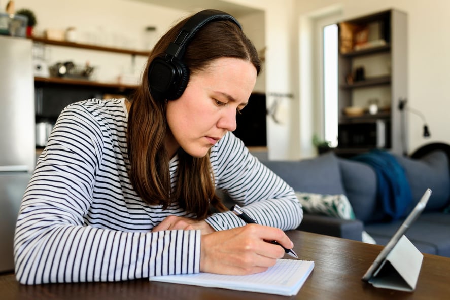 woman-in-headphones-learning-at-home-5FABV36